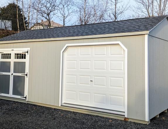 12x24 Peak Storage Shed. Light grey LP SmartSiding siding with white trim. Garage door and double door on a 24' side